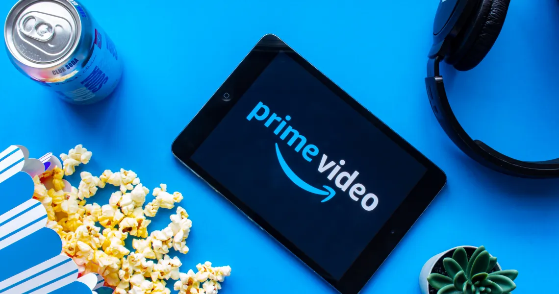 A tablet showing Prime Video next to popcorn and headphones